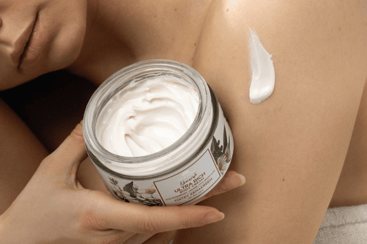 Frau hält Ultra Rich Körpercreme von Magrada – Nourish Körperpflege für trockene Haut