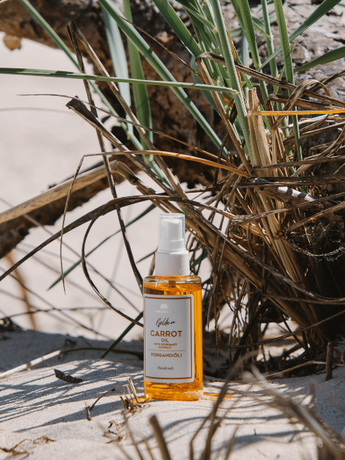 Magrada Golden Carrot Oil Flasche im Sand zwischen Stranddünen