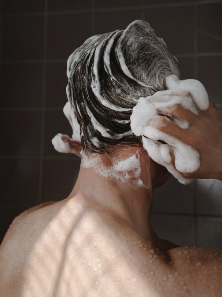 Mann wäscht Haare mit reichem Schaum – festes Shampoo für Männer richtig anwenden
